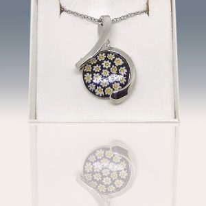 A lovely circle-shaped necklace with an amazing contrast of white daisies on a black backdrop. This necklace was made with the millefiori technique.