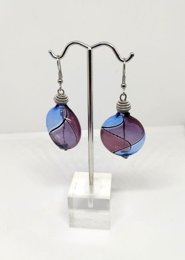 Sky blue, purple and black lines swirl around in these Murano glass earings. Each earring is stopped with metallic coil. 