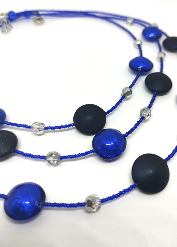 Detail of a three-tiered necklace made of gorgeous black beads peppered and fused with fragments of blue glass.