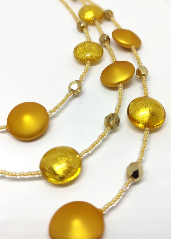 Detail of a three-tiered necklace made of gorgeous golden-yellow beads peppered and fused with fragments of yellow glass.