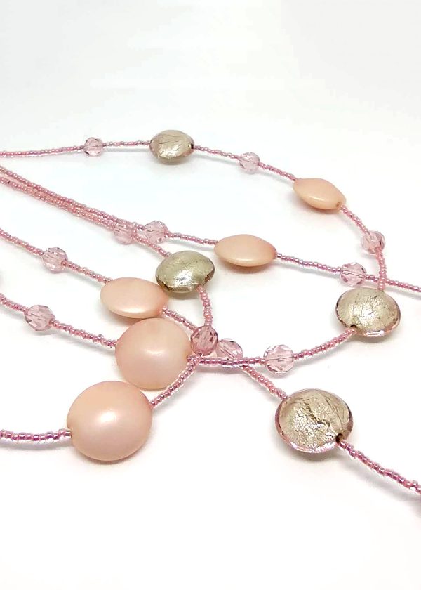 Detail of a three-tiered necklace made of gorgeous delicate-pink beads peppered and fused with fragments of light pink glass.
