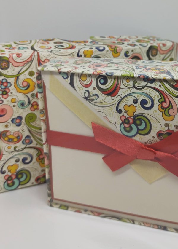Left part of the image, there's an exquisite box adorned with the captivating swirl design.On the right part of the image, you see the inside of the box. It contains a set of beautifully crafted cards and envelopes. The cards likely showcase the same mesmerizing swirl patterns or elegant designs that match the box, creating a harmonious visual experience