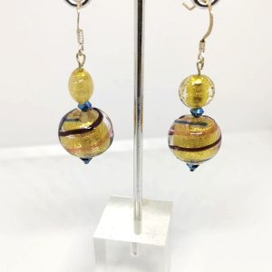 Earrings with a captivating golden yellow base and three swirling lines of blue, orange, and brownish maroon. The earrings are stopped with a blue crystal-like glass.