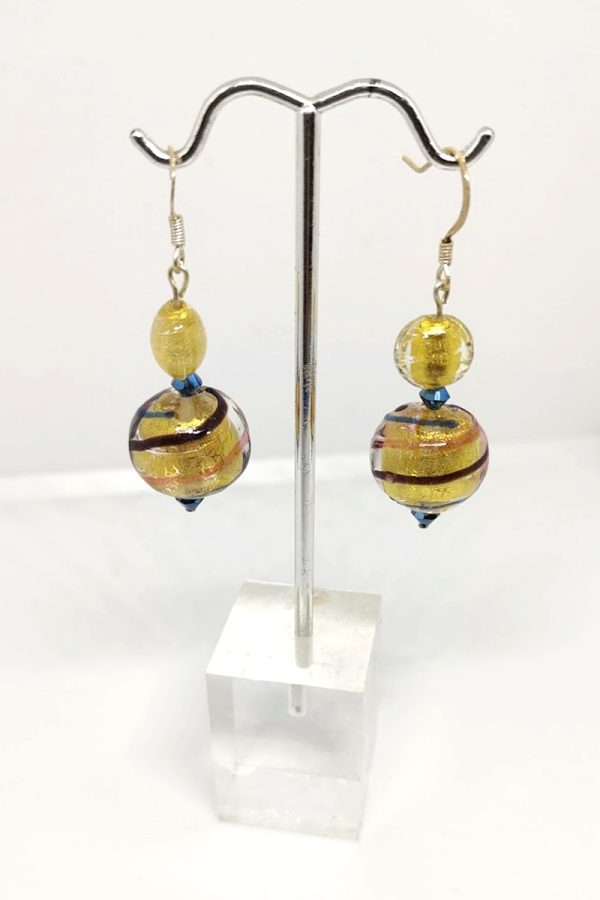 Earrings with a captivating golden yellow base and three swirling lines of blue, orange, and brownish maroon. The earrings are stopped with a blue crystal-like glass.