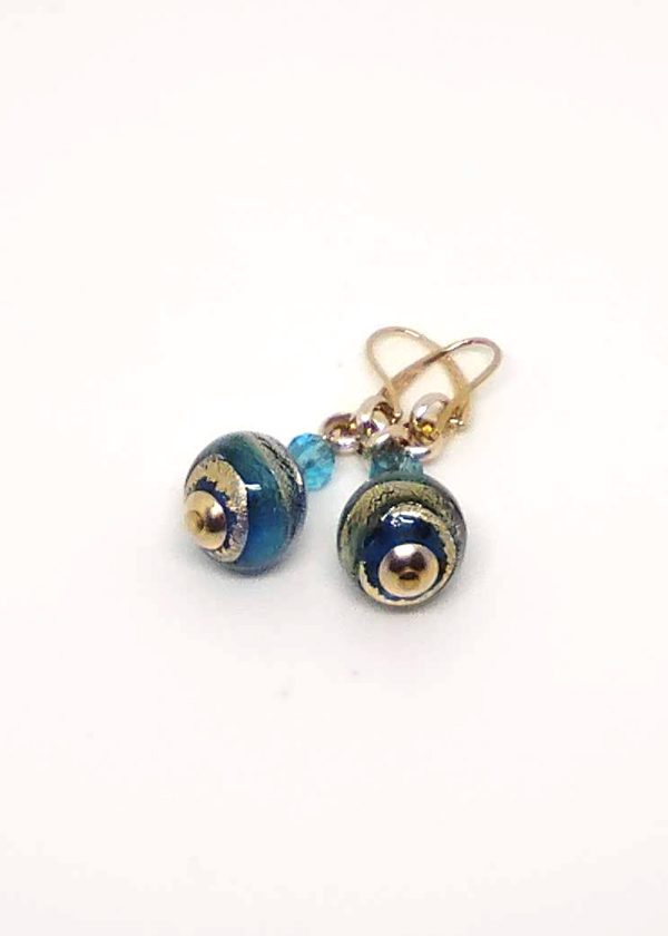 Detail of glass earrings each with 2 beads: a small one in light, clear sky blue and a big one with blue and gold.