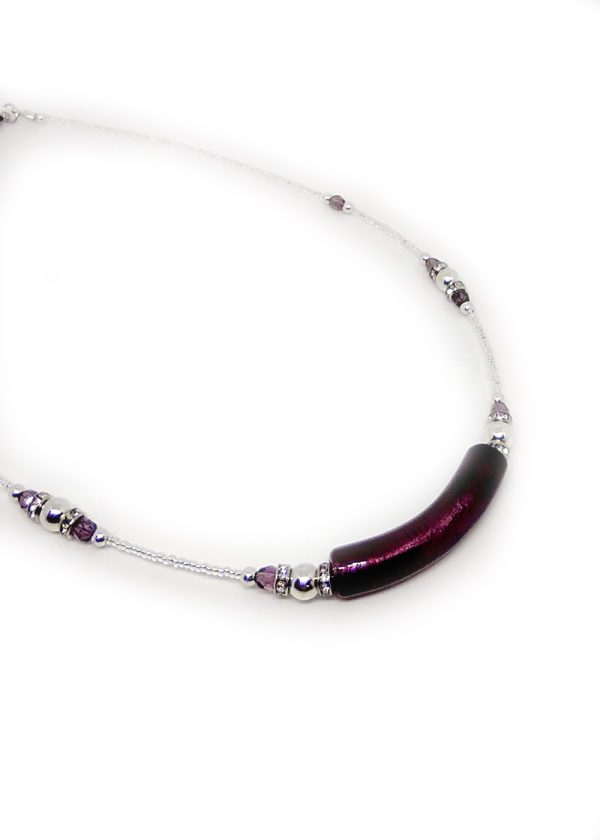 A necklace with a unique detail in the central deep violet blown glass pendant, featuring delicate sequences of deep violet and silver-colored beads around the rest of the necklace.