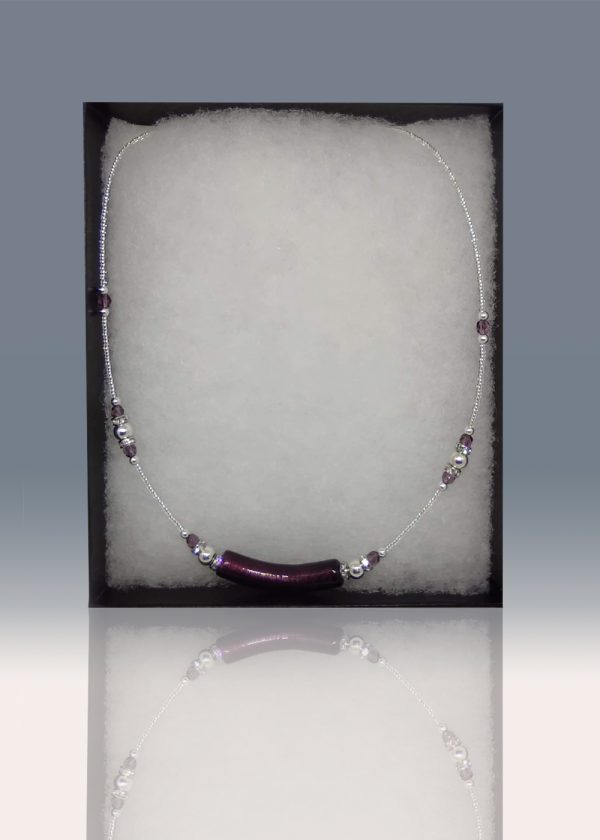A necklace with a unique detail in the central deep violet blown glass pendant, featuring delicate sequences of deep violet and silver-colored beads around the rest of the necklace.