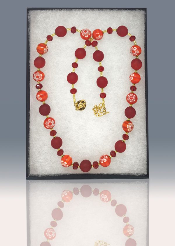 Necklace with blood red frosted beads, red crystal and delicate red and orange striped beads, each with a millefiore flowers separated by tiny golden glass beads.