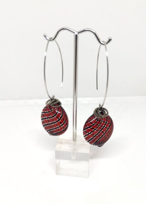 Glass drop earrings with a deep red and black lines beads and metal coil