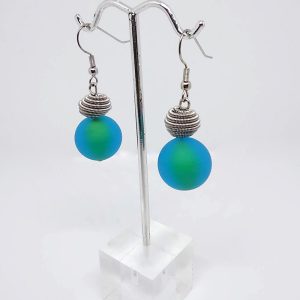 Earrings made with frosted turquoise-colored Murano glass round beads and metallic coil accents resting on top.