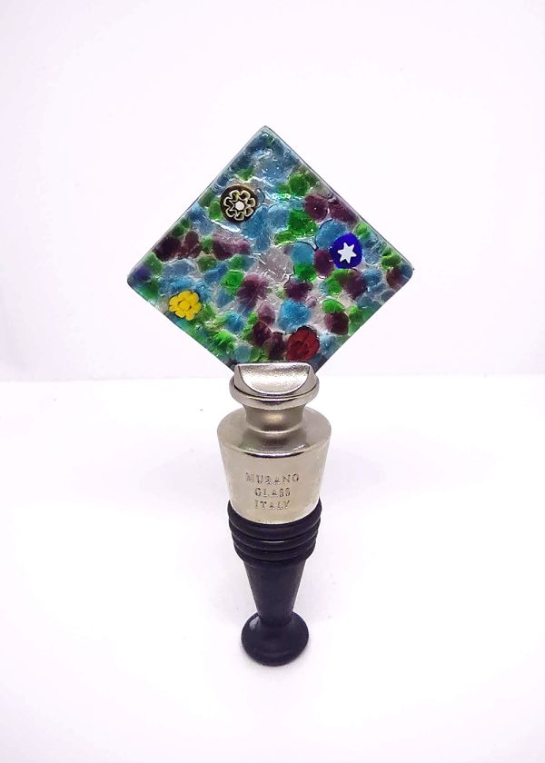 Wine stopper with a square base made of bright greens, blues, and purples, with a splash of mismatched flowers.
